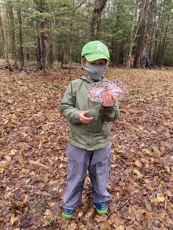 Student holding toad pictures on hands