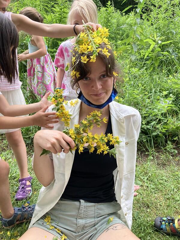 Camp Staff Ciara gets decorated in yellow flowers to match the fairy houses