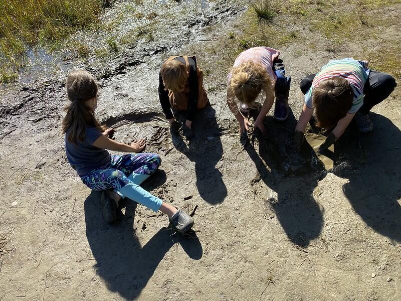 Students playing in the mud