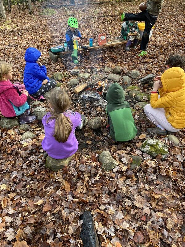 student sitting around a campfire