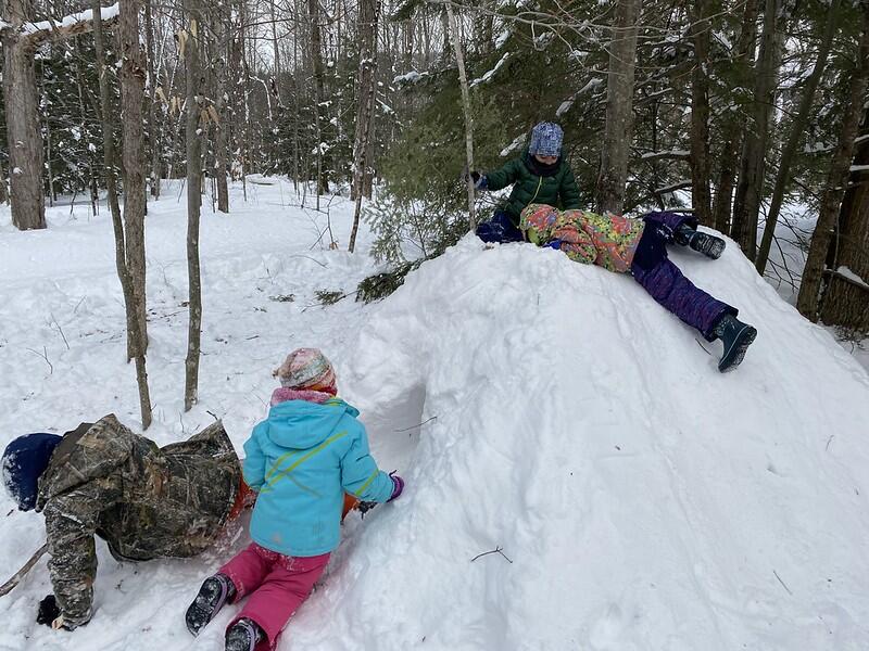 student playing on snow pile