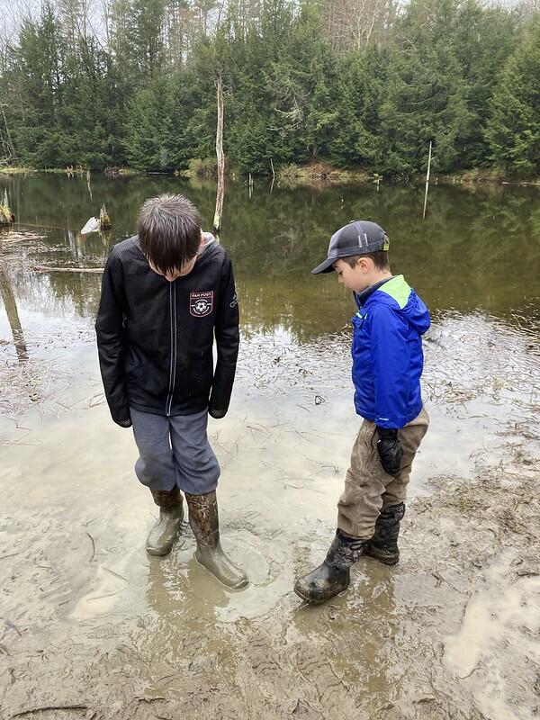 two students standing in the mud