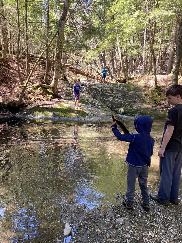 Brook with students on rocks