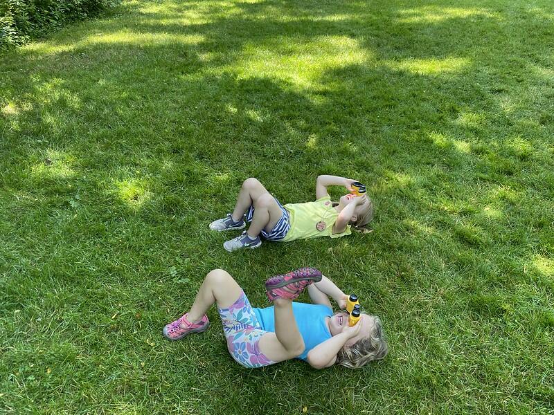 campers laying on the grass using binoculars