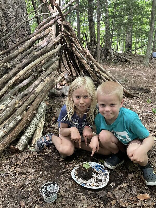 Two campers cooking with mud