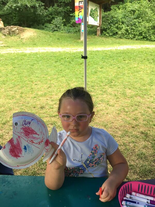 Student holding up paper plate fish