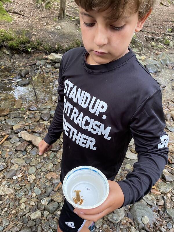 camper with a crayfish in a yogurt cup