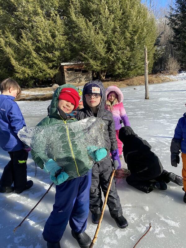 student holding ice on pond
