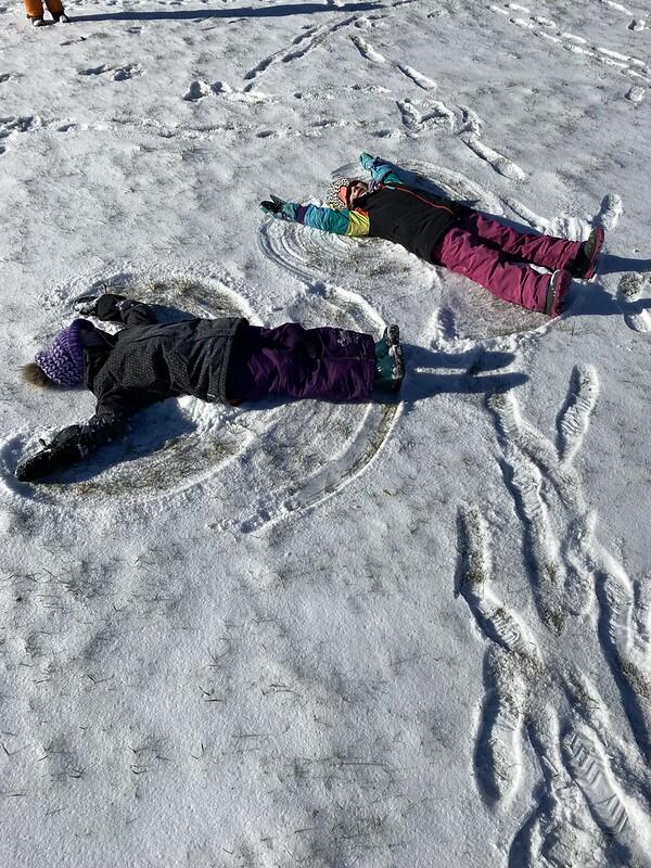 two students making snow angels 