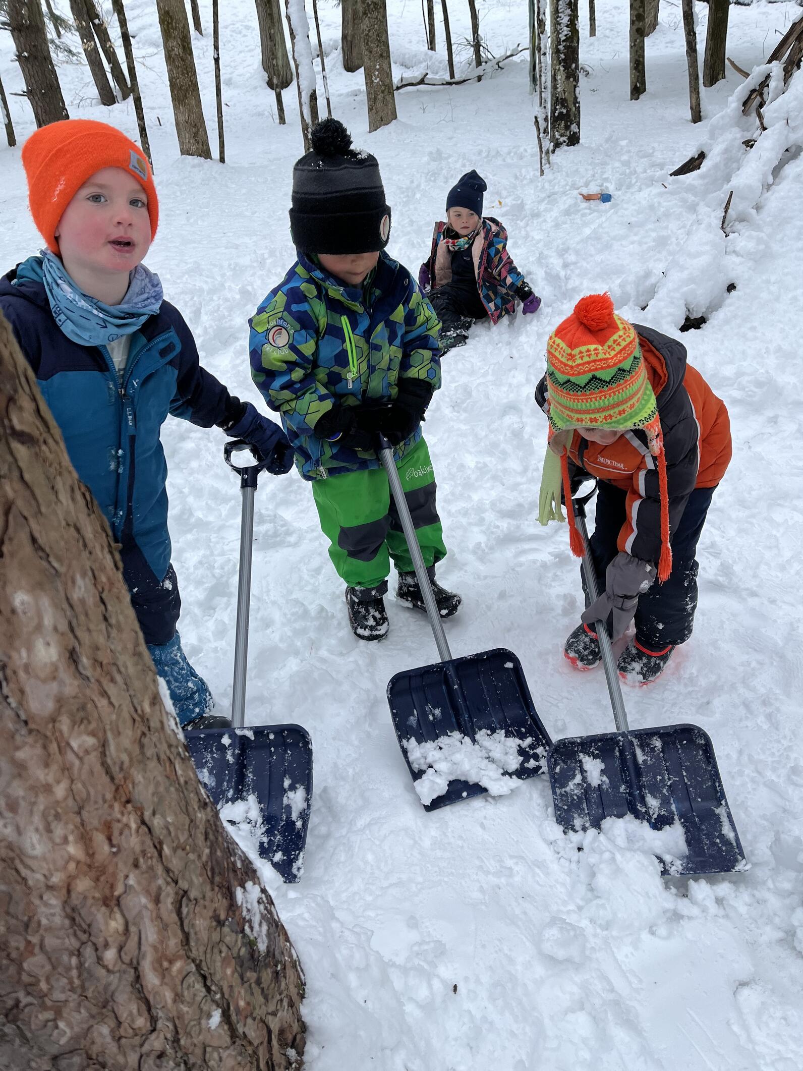 children play in the snow with shovels