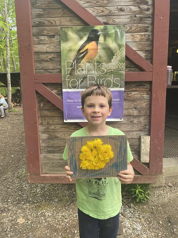 Student standing with artwork