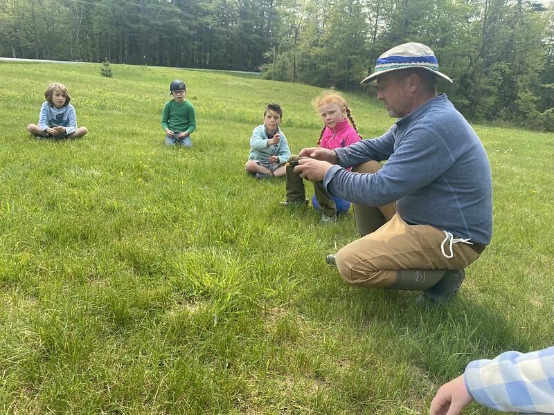 Students seeing Mark hold a robin