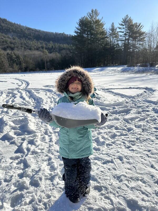 Student holding snow in shovel