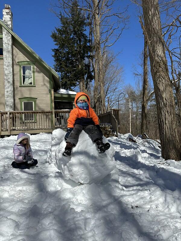 student sitting on snowball