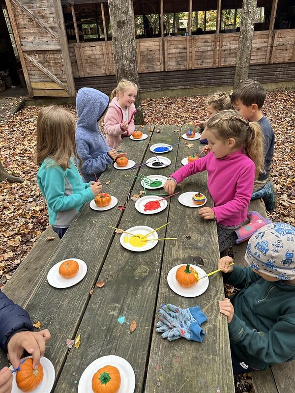 students painting pumpkins