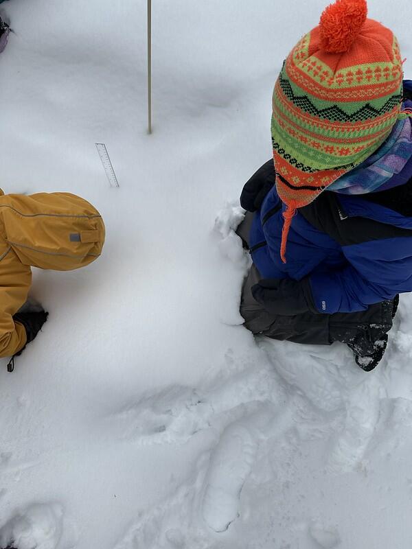 student measuring the snow