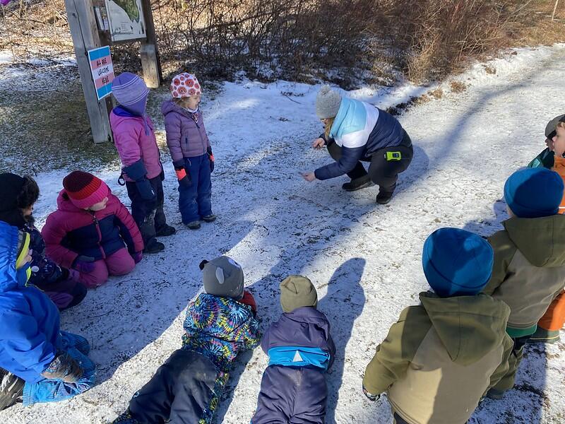 Children gather around a crouching adult