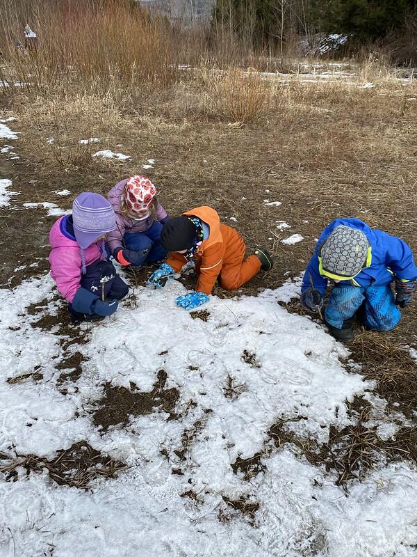 children look at snow on the ground