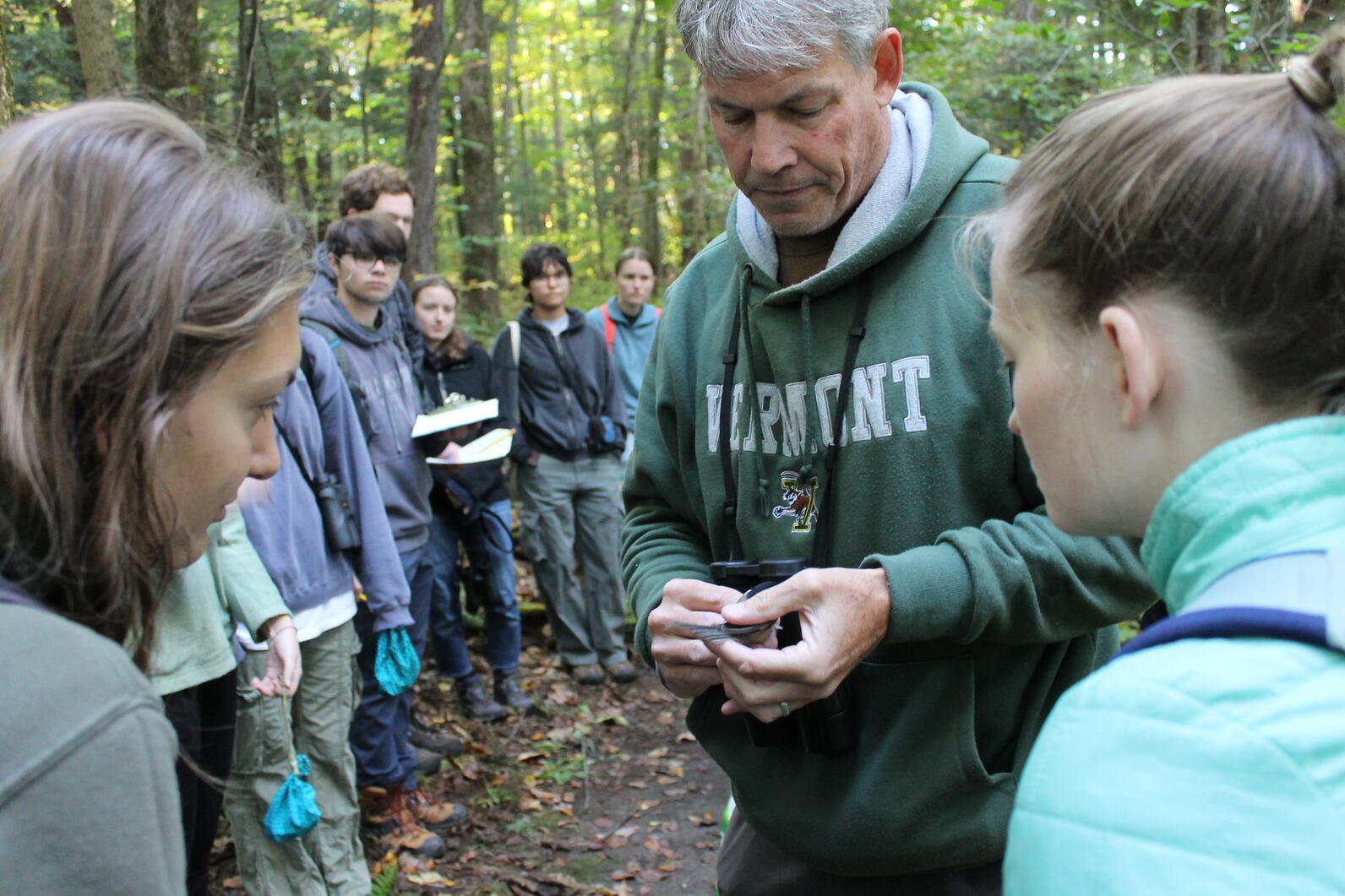 Professor Strong holds a chickadee to show students the buffy tips on the primary coverts.