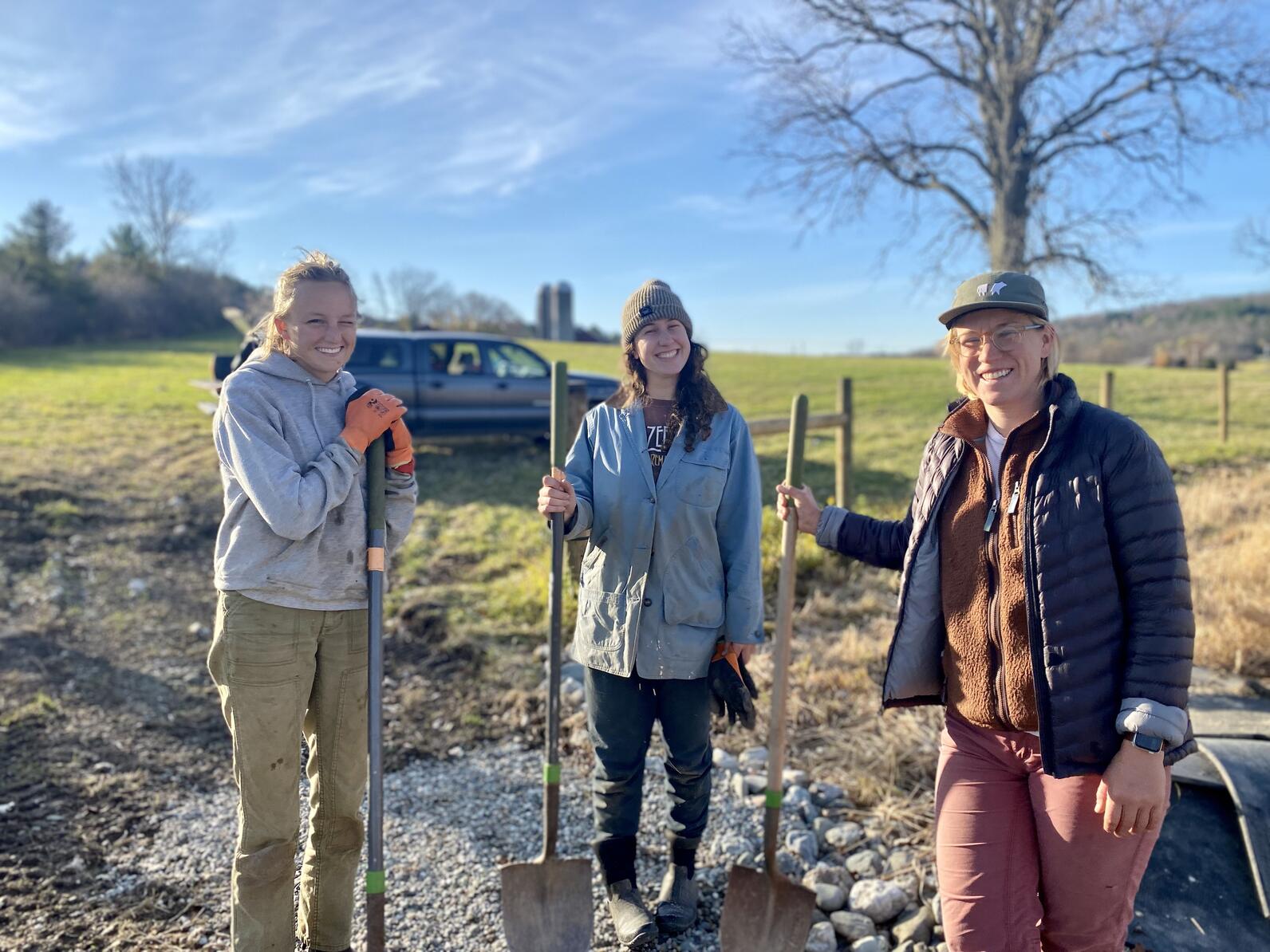 A group of three people holding shovels