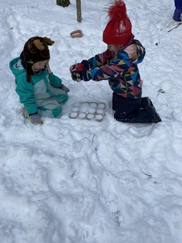 two children play in the snow