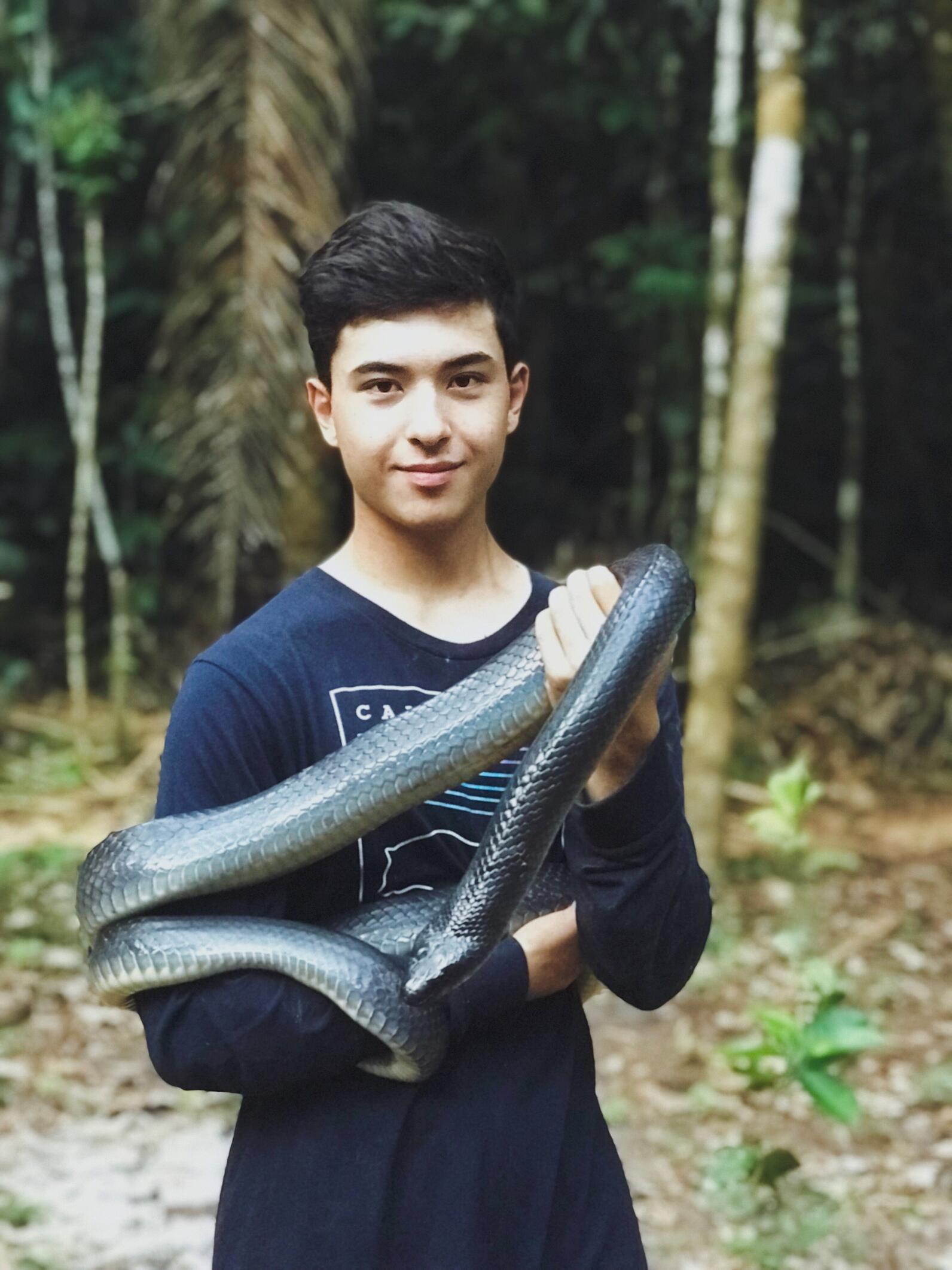 AmeriCorps member Truman holds a very large black and pale yellow Mussurana 