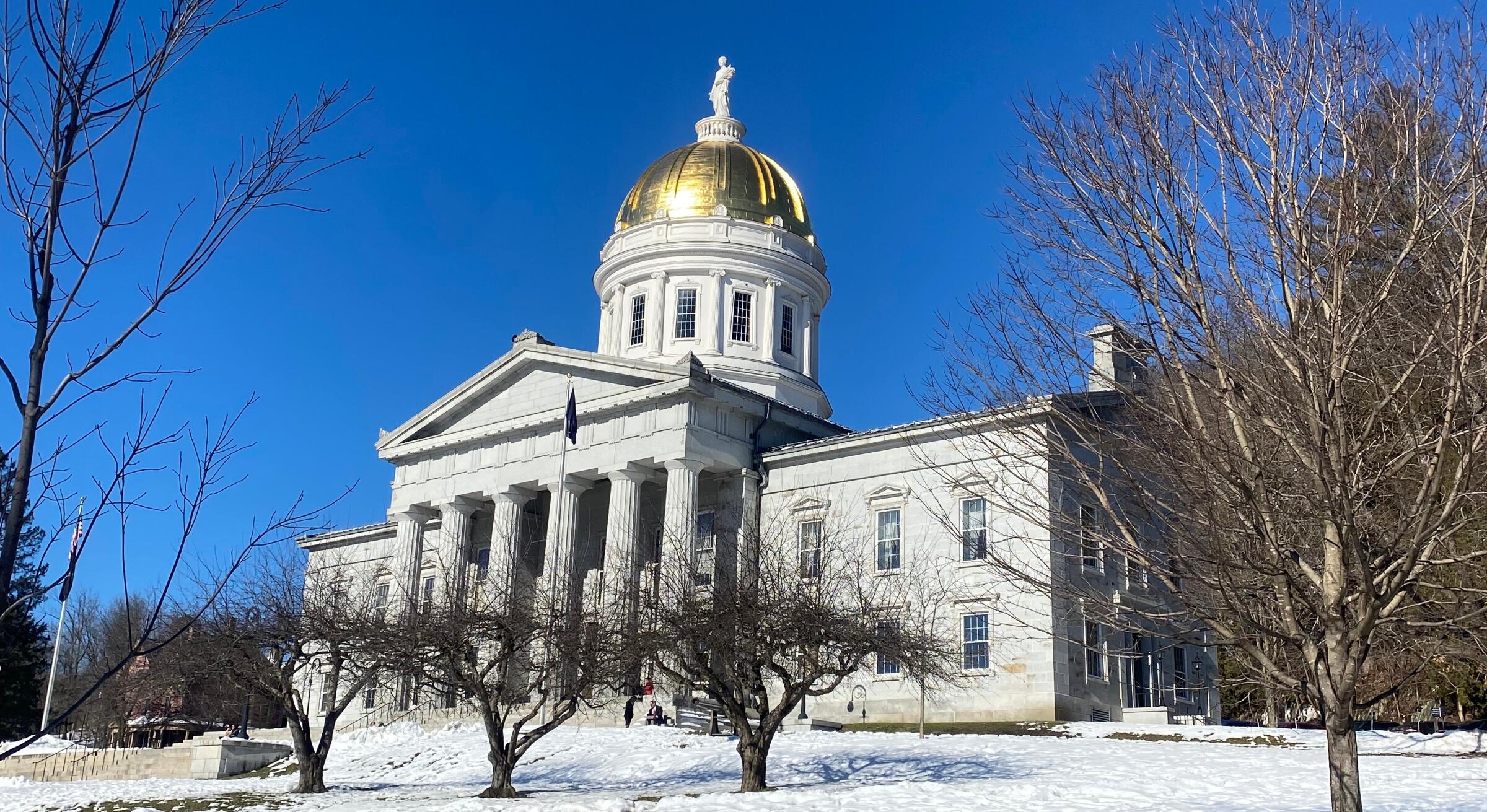 A photo of the Vermont State House with snow on the lawn.