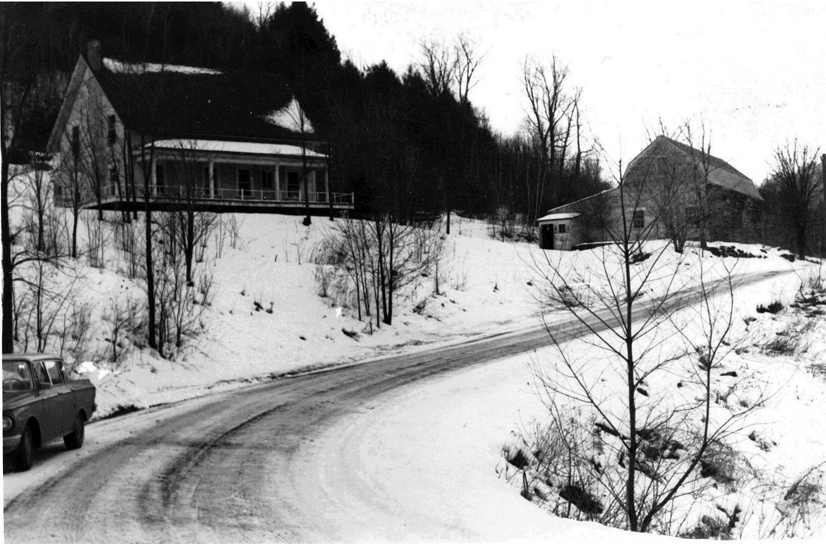 A black and white photo of the GMAC Visitor Center and Education Barn, seen from the road in the 1960s.